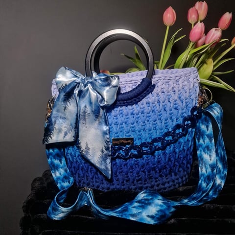 Blue patterned handbag with silver handles, decorative bow, and pink tulips