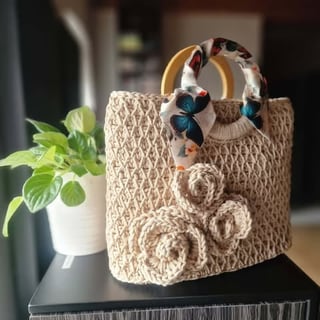 Beige crocheted handbag with wooden handles and decorative flower appliques