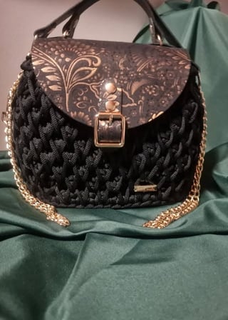Black quilted shoulder bag with ornate leather flap and gold chain strap