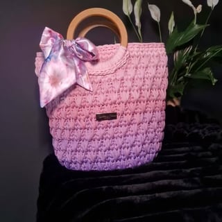 Pink quilted handbag with wooden handles and purple silk bow accent