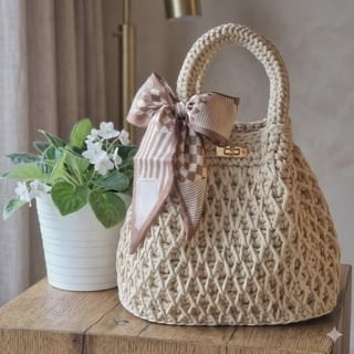 Beige woven handbag with ribbons on wooden table