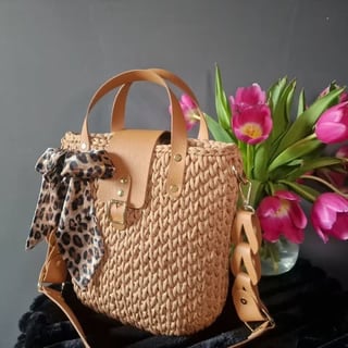 Beige woven handbag with leather handles and animal print scarf